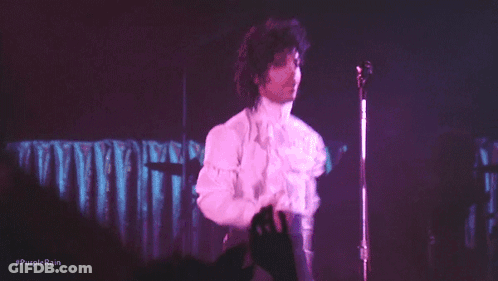 A Person Is Playing A Keyboard With Purple Lights Behind Them GIF