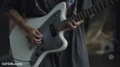 A Person Is Playing A White Guitar With A Sticker On The Bottom That Says ' Let 'S Talk Rock ' GIF