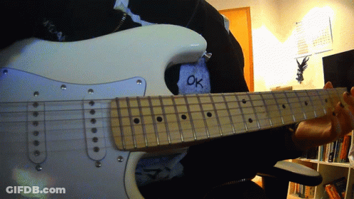 A Person Is Playing An Electric Guitar With The Word Ok Written On Their Shirt GIF