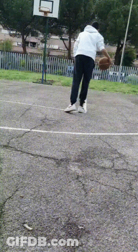 A Person Is Playing Basketball On A Concrete Court GIF