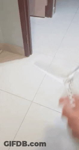 A Person Is Playing With A Toy On A Tile Floor GIF