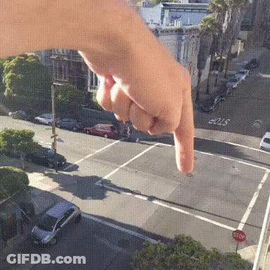 A Person Is Pointing At A Stop Sign GIF