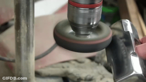 A Person Is Polishing A Piece Of Metal With A Polisher GIF