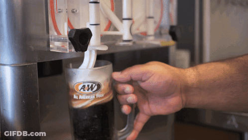 A Person Is Pouring A Beverage From A Machine That Says Aw GIF