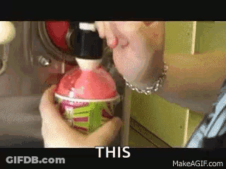 A Person Is Pouring A Drink Into A Cup And The Words This Are On The Bottom Of The Image . GIF