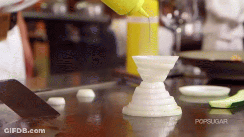 A Person Is Pouring A Yellow Liquid Into A White Container With The Word Popsugar On The Bottom GIF