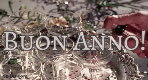 A Person Is Pouring Champagne Into A Pyramid Of Champagne Glasses With The Words Buon Anno In The Background . GIF