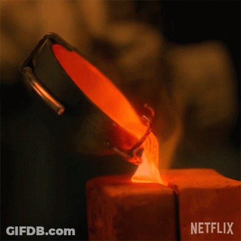 A Person Is Pouring Molten Metal Into A Piece Of Wood . GIF
