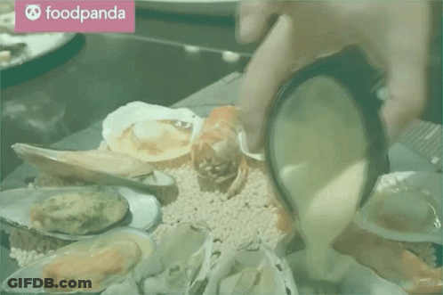 A Person Is Pouring Sauce Into A Plate Of Seafood With A Foodpanda Logo In The Background GIF