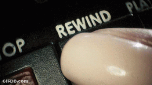 A Person Is Pressing A Button That Says Rewind On It GIF