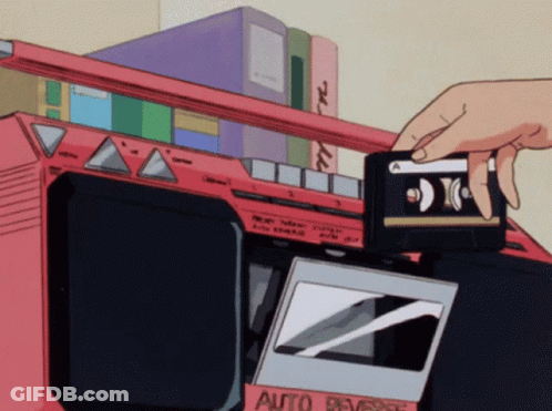 A Person Is Putting A Cassette Tape Into An Auto Reverse Cassette Player GIF