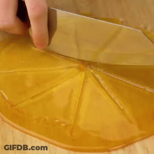 A Person Is Putting A Doughnut On Top Of A Chocolate Cake On A Wooden Cutting Board . GIF
