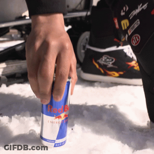 A Person Is Reaching For A Can Of Red Bull In The Snow GIF