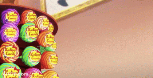 A Person Is Reaching For A Lollipop In A Display Of Lollipop Candy GIF