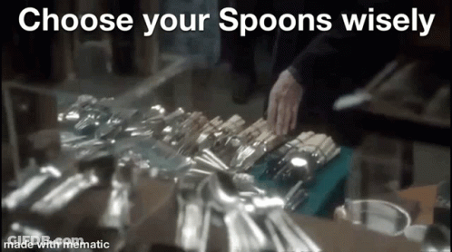 A Person Is Reaching For A Spoon In A Pile Of Silverware On A Table . GIF