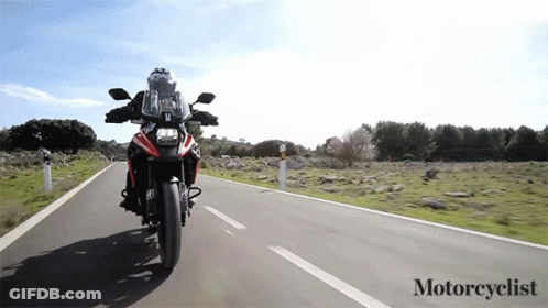 A Person Is Riding A Motorcycle Down A Road With The Words Motorcyclist Below It GIF