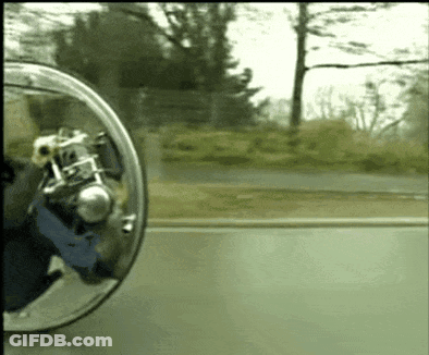 A Person Is Riding A Motorcycle On A Road With A Rear View Mirror Behind Them GIF