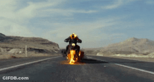 A Person Is Riding A Motorcycle That Is On Fire On The Road GIF