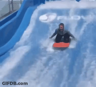 A Person Is Riding A Surfboard Down A Water Slide In The Water . GIF