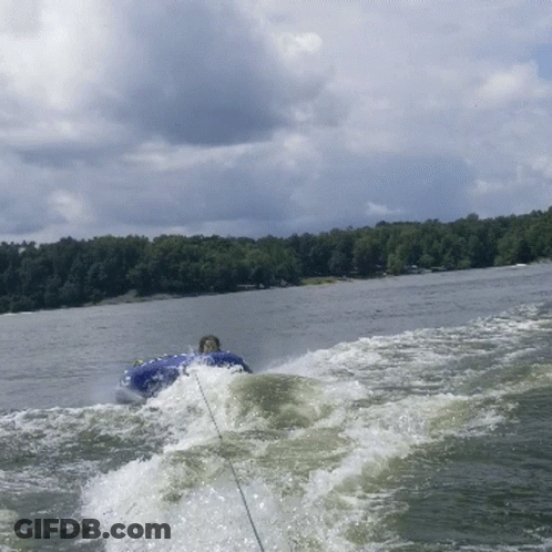 A Person Is Riding A Tube On A Lake GIF