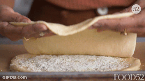 A Person Is Rolling A Piece Of Dough With Food52 On The Bottom Right GIF