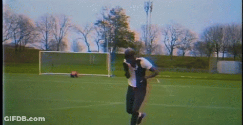 A Person Is Running On A Soccer Field With A Goal In The Background . GIF