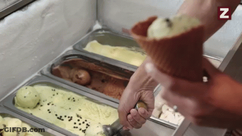 A Person Is Scooping Ice Cream Out Of A Cone With A Spoon .. GIF