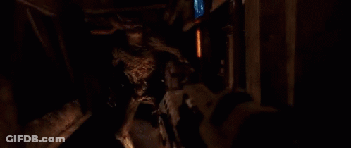A Person Is Shooting A Gun In A Dark Room And There Is A Lot Of Smoke Coming Out Of The Gun . GIF