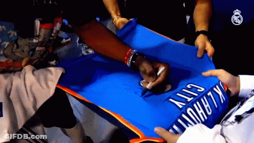 A Person Is Signing A Blue Oklahoma City Jersey GIF