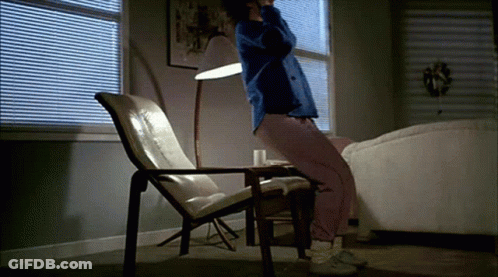A Person Is Sitting In A Chair In A Living Room GIF