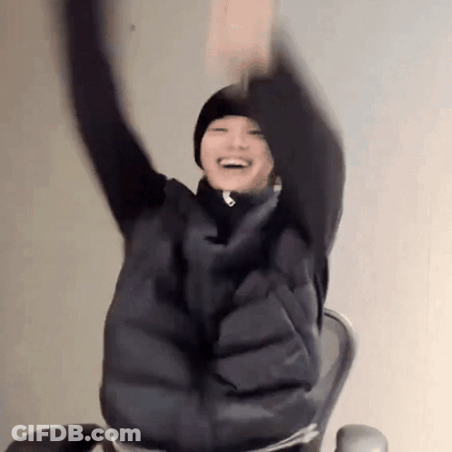 A Person Is Sitting In A Chair With Their Arms Up In The Air . GIF