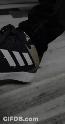 A Person Is Sitting On A Couch Wearing Adidas Shoes GIF