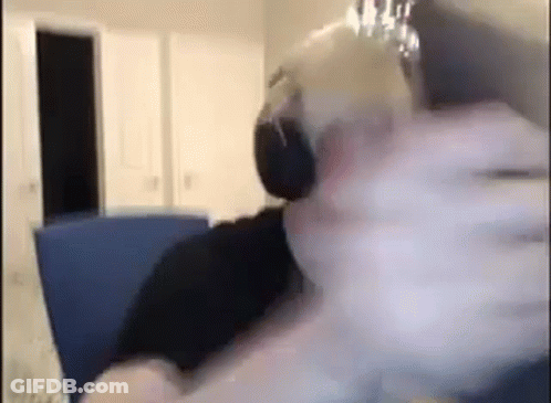 A Person Is Sitting On A Couch Wearing Headphones While Holding A Glass Of Water . GIF