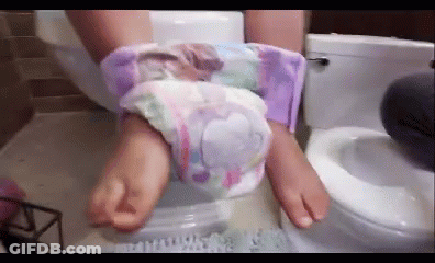 A Person Is Sitting On A Toilet With Their Feet In A Diaper . GIF