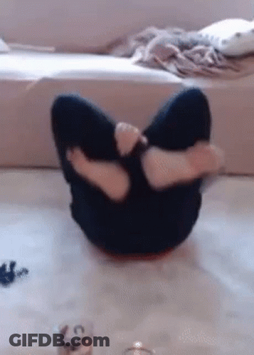 A Person Is Sitting On The Floor With Their Legs Crossed And A Candle In The Background . GIF