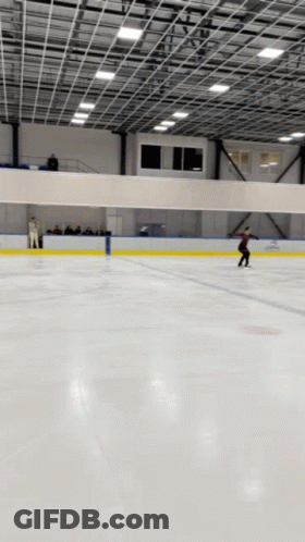 A Person Is Skating On A Ice Rink In A Stadium GIF