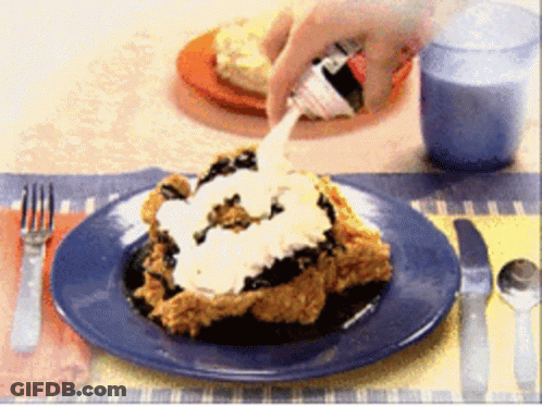A Person Is Spreading Whipped Cream On A Piece Of Food On A Plate GIF