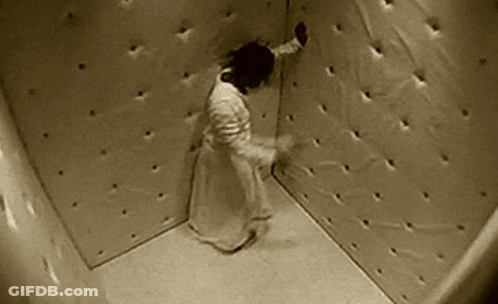 A Person Is Standing In A Corner Of A Room With Holes In The Walls . GIF