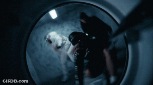 A Person Is Standing In A Dark Room With A 100 Dollar Bill On The Wall GIF