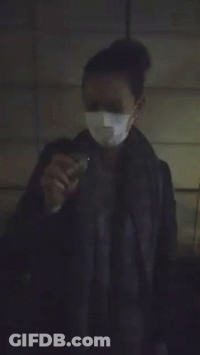 A Person Is Standing In A Dark Room With A Bright Light Coming From Behind Them GIF