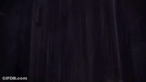 A Person Is Standing In A Dark Room With A Sword In Their Hand GIF