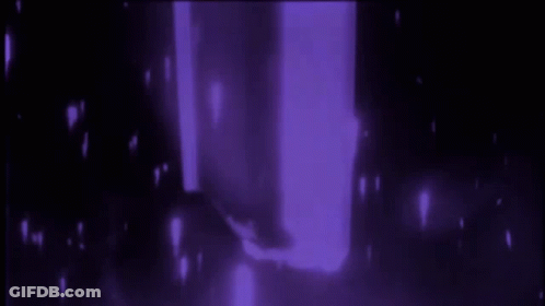 A Person Is Standing In A Dark Room With Purple Lights Behind Them GIF