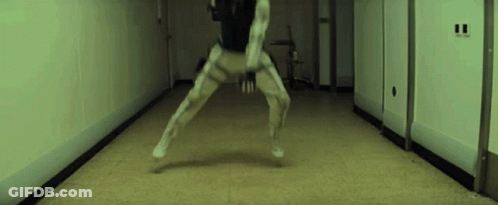 A Person Is Standing In A Hallway With Their Legs Crossed . GIF