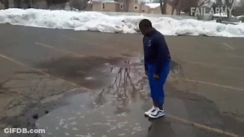 A Person Is Standing In A Puddle Of Water In A Parking Lot With Failarmy Written On The Bottom GIF