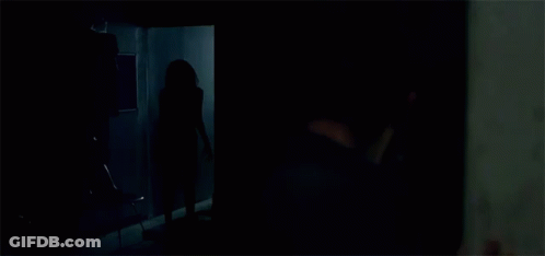A Person Is Standing In A Room With Clothes Hanging On The Racks GIF