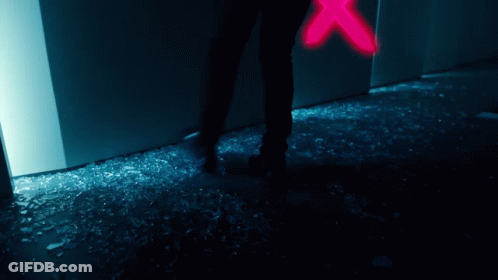 A Person Is Standing In Front Of A Broken Glass Door GIF