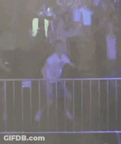 A Person Is Standing In Front Of A Fence With A Fireball Coming Out Of The Fence . GIF