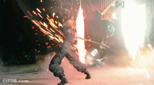 A Person Is Standing In Front Of A Fire With A Sword . GIF