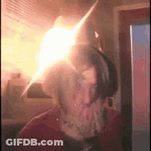 A Person Is Standing In Front Of A Fridge With A Light Coming Out Of The Fridge . GIF