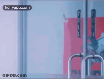 Person Standing In Front Of Glass Door With Handle GIF